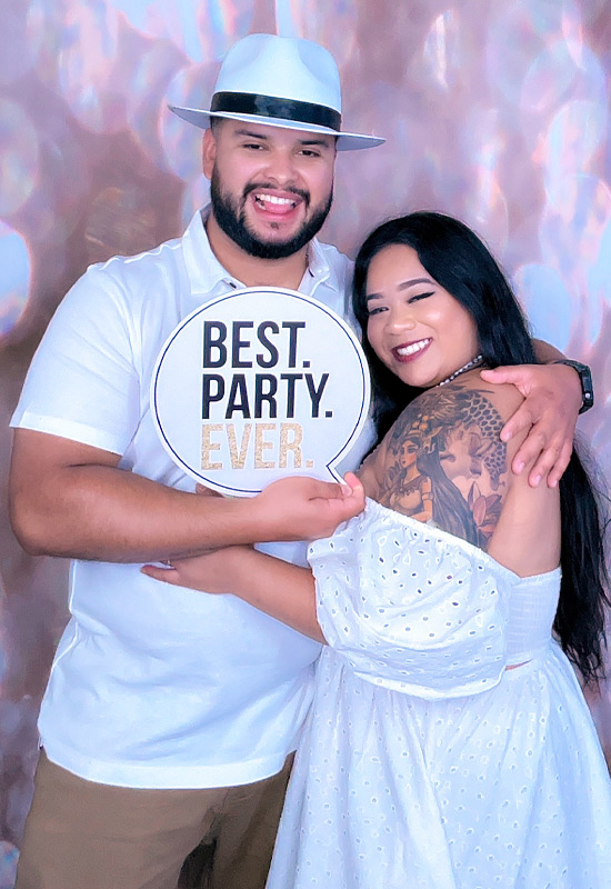 Couple posing for glamoor photo booth at a party in los angeles holding a prop that says best party ever