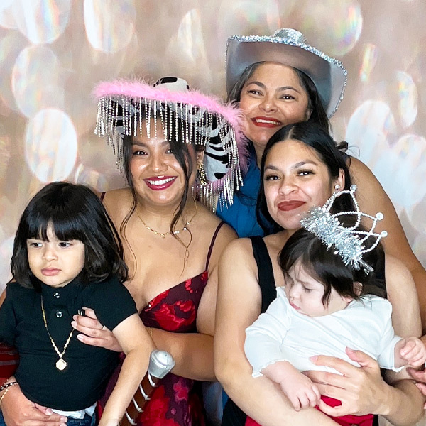 a mom with her 2 daughters using a photo booth at a birthday celebration in carson california