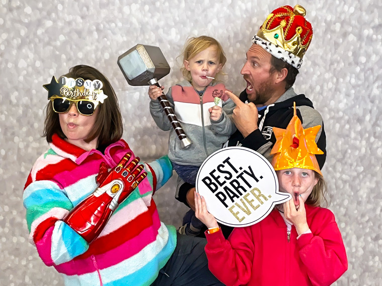 Family group smiling and posing with silly photo booth props at a school event in Torrance, California