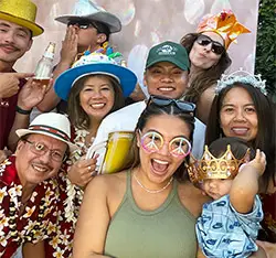 Family posing with fun props at a Hawaiian theme birthday photo booth in Carson, CA